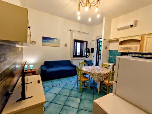 a living room with a blue couch and a table at Villetta Marina in Roseto degli Abruzzi