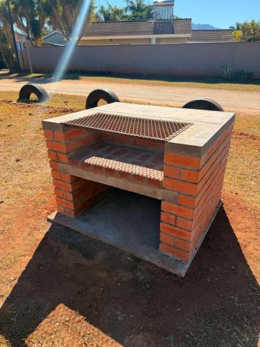a brick bench sitting on top of a field at WeMukelekile (you are welcome) in Lobamba