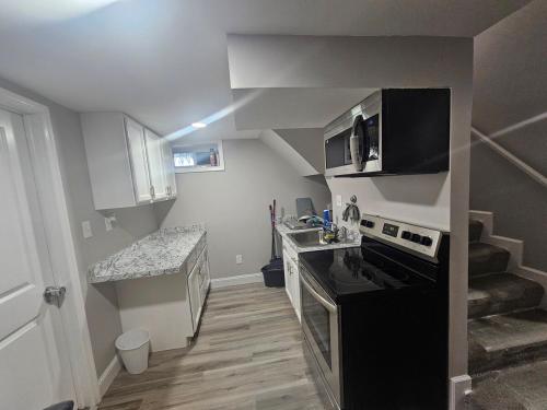 una pequeña cocina con fogones y una escalera en Welcome to Our House, en Woodlawn