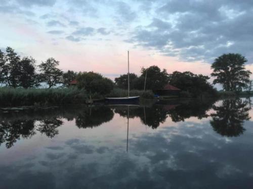 a boat is sitting on the water with at Docklodge at Frisian Lakes with Private Mooring in Delfstrahuizen