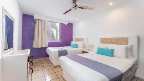 a hotel room with two beds and a bathroom at Best Western Posada Chahue in Santa Cruz Huatulco