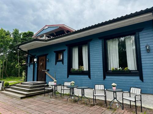 a blue house with chairs and a table in front of it at Majatalo Tyrni in Nakkila