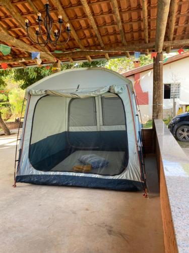 a tent is set up under a roof at Chácara Namorada do Sol - Pousada e Camping in Guaxupé