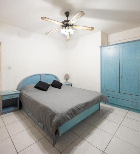 a bedroom with a bed with a ceiling fan at Your west coast getaway in Flic-en-Flac