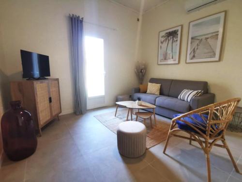 a living room with a couch and a table at Le Cocon - Rénové I Clim I Terrasse I WIFI I Hypercentre in Miramas