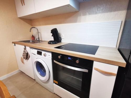 a kitchen with a sink and a washing machine at Le Cocon - Rénové I Clim I Terrasse I WIFI I Hypercentre in Miramas