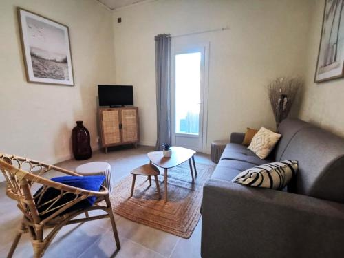 a living room with a couch and a table at Le Cocon - Rénové I Clim I Terrasse I WIFI I Hypercentre in Miramas