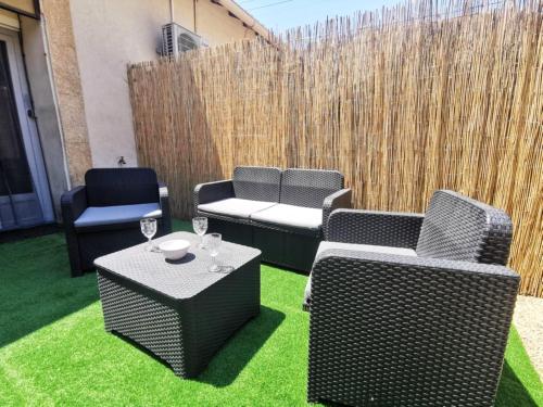 a patio with three chairs and a table and a fence at Le Cocon - Rénové I Clim I Terrasse I WIFI I Hypercentre in Miramas