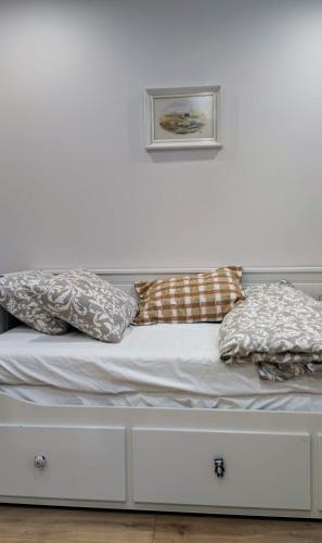 a white bed with pillows on top of it at Apartament Wysoka 580 z prywatną łazienką in Bielawa
