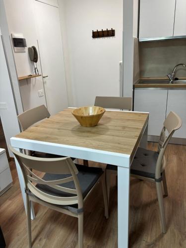 a wooden table with two chairs and a bowl on it at Soleneve in Passo del Tonale