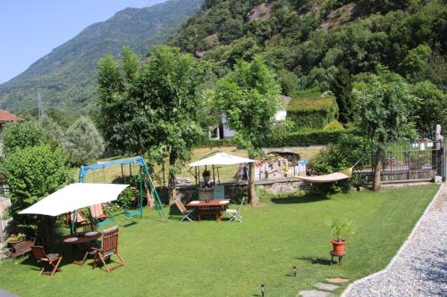 a garden with tables and chairs and a playground at La Ghita in Sparone