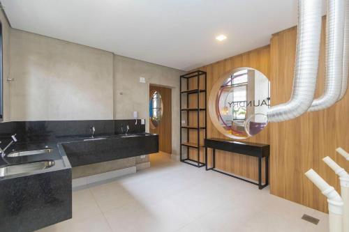 a bathroom with a sink and a mirror at Apto no All Batel finamente mobiliado perto do shopping Curitiba in Curitiba
