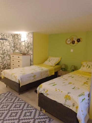 a bedroom with two beds and a dresser at fleurs de printemps - Jonquille chic in Vrécourt