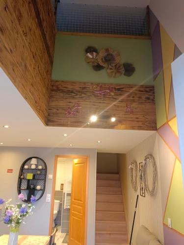 a room with a staircase and a ceiling with flowers at fleurs de printemps - Jonquille chic in Vrécourt