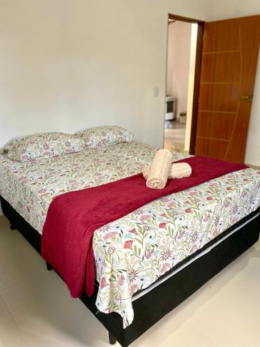 a bedroom with a bed with a phone on it at Casa Lilás no Vale do Capão in Vale do Capao