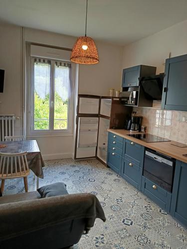 - une cuisine avec un canapé et une table dans une chambre dans l'établissement Doux Ombrages, à La Bourboule