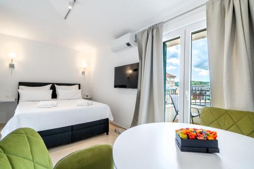 a hotel room with a bed and a balcony at Villa Levante Apartments in Sumartin
