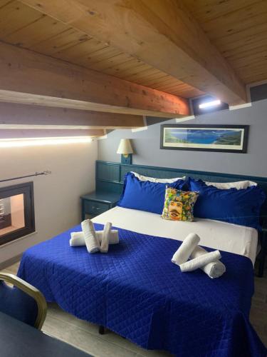a bedroom with a blue bed with towels on it at U muragliuni 1 in Lascari