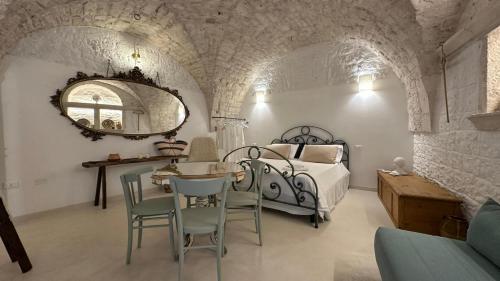 a bedroom with a bed and a table and chairs at La bottega di zia Tetta - Luxury Home in Ceglie Messapica