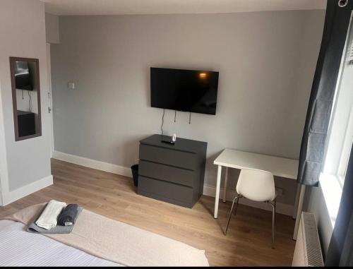 a bedroom with a desk and a television on a wall at Musselburgh Apartment with 3 Bedrooms in Musselburgh