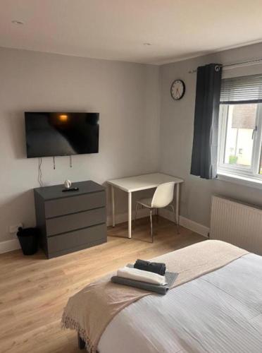 a bedroom with a bed and a desk and a television at Musselburgh Apartment with 3 Bedrooms in Musselburgh