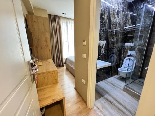 a bathroom with a toilet and a glass shower at 4R Colombo Hotel in Tirana
