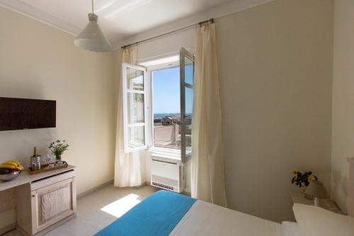 ein Schlafzimmer mit einem Bett und einem großen Fenster in der Unterkunft Brezza Marina Luxury Rooms in Cagliari