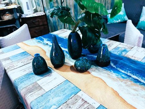 a table with four blue vases sitting on it at A meravigghia casa vacanze in Bagheria