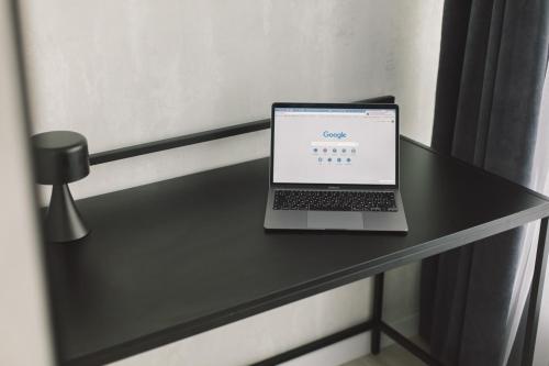einen Laptop auf einem schwarzen Tisch in der Unterkunft День&Ніч метро Харківська in Kiew