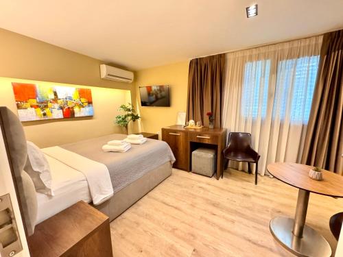 a hotel room with a bed and a desk at 4R Colombo Hotel in Tirana
