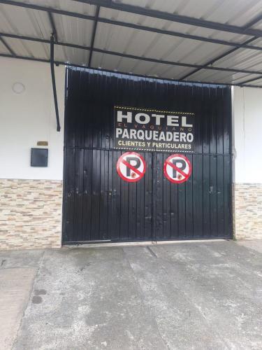 a black garage door with two signs on it at HOTEL EL VAQUIANO o FINCA ALTAMIRA in Estación El Salto