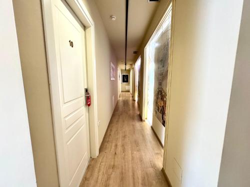 a long hallway with white walls and wooden floors at 4R Colombo Hotel in Tirana