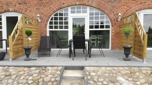 a patio with a table and chairs in front of a building at Gutshaus Wohlenhagen in Wohlenberg
