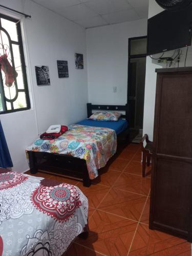 a bedroom with two beds and a window at HOTEL EL VAQUIANO o FINCA ALTAMIRA in Estación El Salto