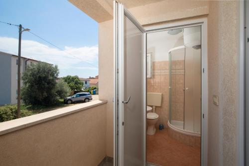 a glass door leading to a bathroom with a toilet at Sea Nest Ližnjan 2 in Ližnjan
