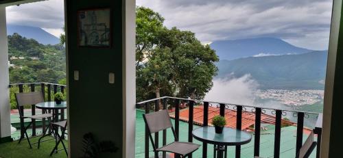 a balcony with tables and chairs and a view at Hotel El Tambor OASIS Antigua Guatemala in Antigua Guatemala
