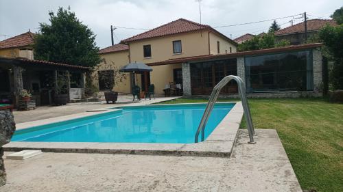 a swimming pool in front of a house at Casa de Penim in Paredes de Coura