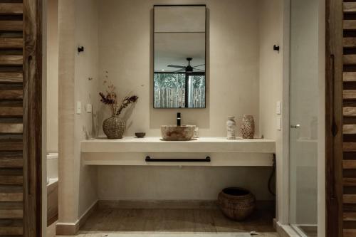 a bathroom with a sink and a mirror at Ka'ana Condo in Tulum