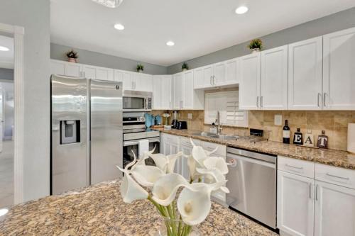 a kitchen with white cabinets and stainless steel appliances at Barefoot In Lantana in Lantana