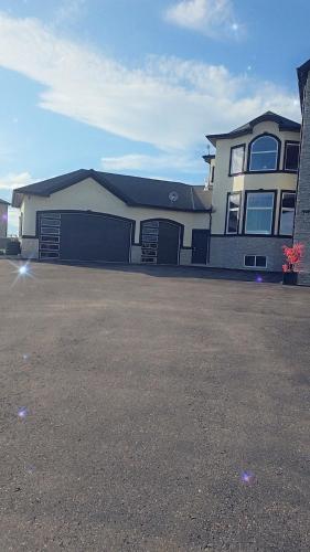 a large house with a large driveway in front of it at Golden Acreage Getaway 2 Bedroom in Balzac