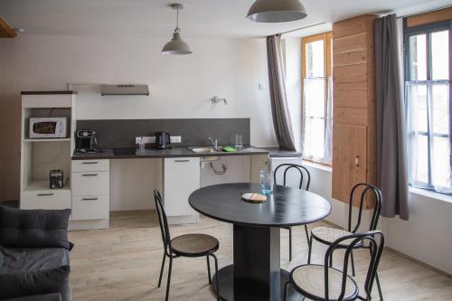 - une cuisine et une table avec des chaises dans la chambre dans l'établissement Gîte PMR - Le petit atelier de Marius, à Artonne