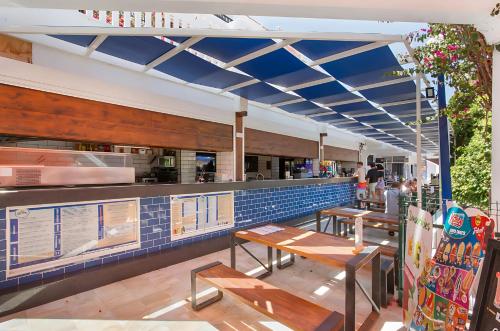 a restaurant with wooden tables and a counter at Sunny Escape, Parque Santiago 2 in Arona