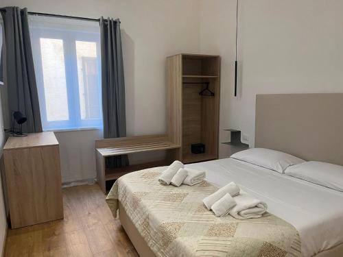 a bedroom with a bed with towels on it at La Terrazza in centro in Marsala