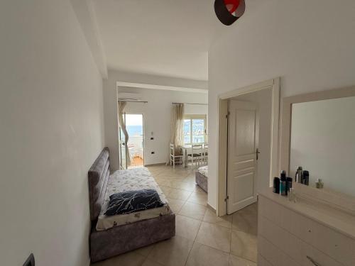 una camera da letto con un letto e una sedia in una stanza di Nick's Apartment a Sarandë