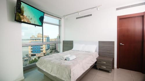 a bedroom with a bed and a flat screen tv at Suite 7 Riverfront 1, Puerto Santa Ana, Guayaquil in Guayaquil