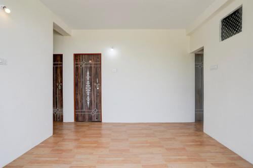 an empty room with white walls and a door at Hotel O Sky Villa in Nagpur