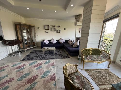 a living room with a blue couch and chairs at Sky Appartments in Cairo