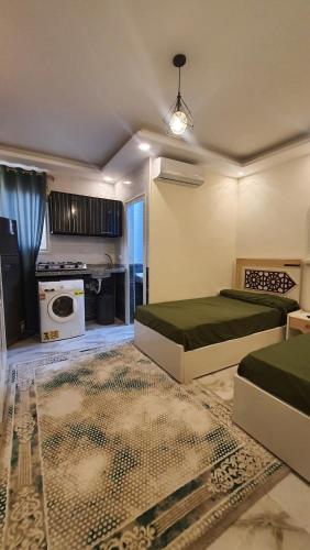 a living room with two beds and a stove at العجمي 300 in 6th Of October