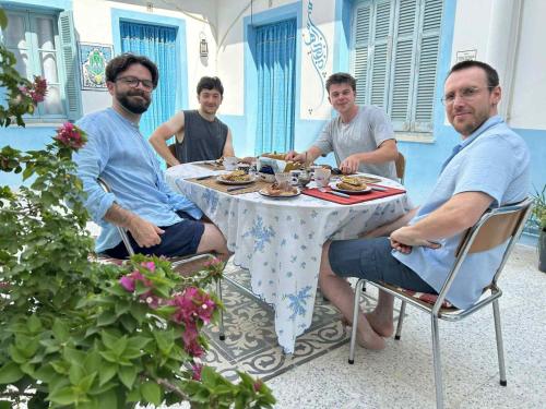 a group of men sitting around a table eating food at Dar Hkaïem in Hammam Sousse