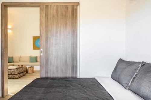 a bedroom with a bed and a living room at Revery house in Ios Chora